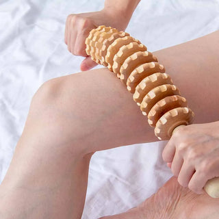 Wood therapy massage roller rolled over the knee and calf during a self-massage